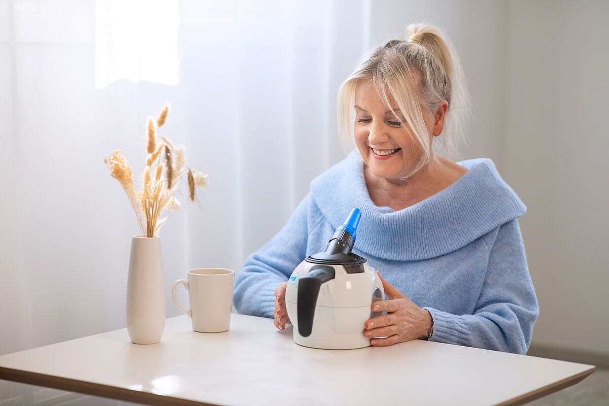 A happy person holding the WellO2 breathing exercise device