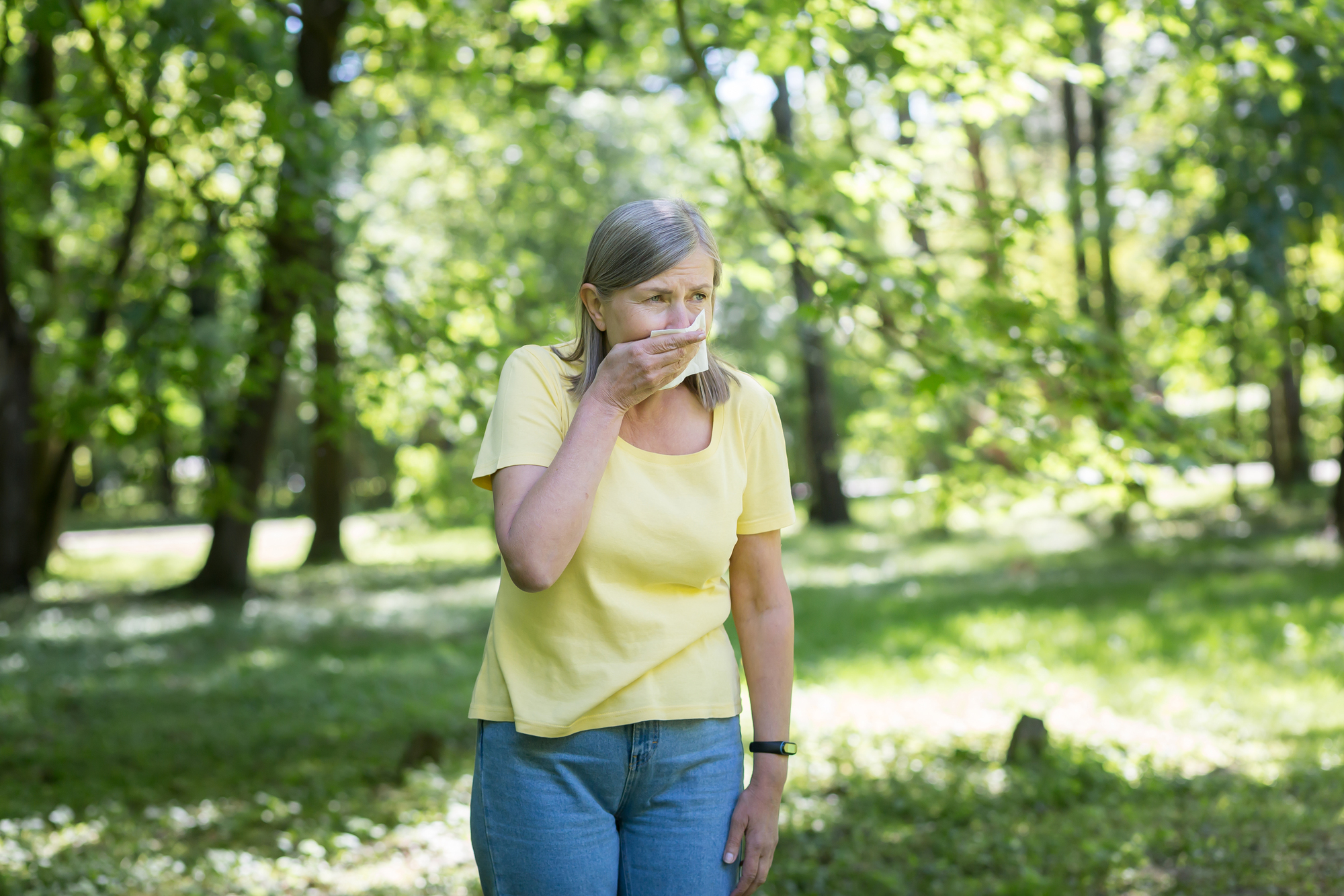 An elderly woman in the park with allergies